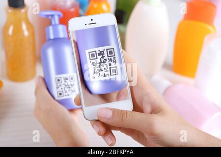 Frau scannt Gutschein-Code mit Handy aus nächster Nähe Stockfoto