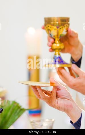 In der Kirche wird Wein zum Blut christi, und die Hostie wird zum Leib christi Stockfoto