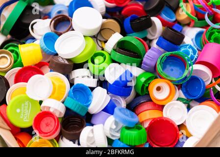 Plastikkappen in einer Tasche. Viele Plastikflaschen-Kappen. Die Kampagne für die getrennte Abfallsammlung. Stockfoto