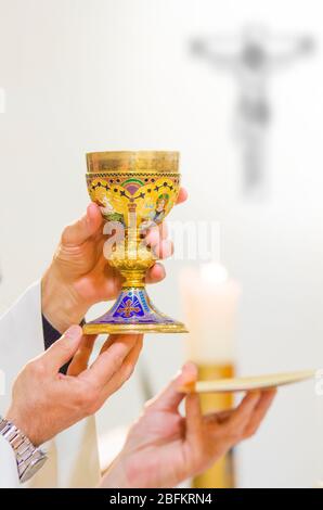 In der Kirche wird Wein zum Blut christi, und die Hostie wird zum Leib christi Stockfoto