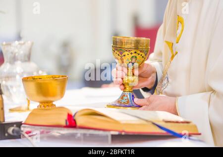 In der Kirche wird Wein zum Blut christi, und die Hostie wird zum Leib christi Stockfoto