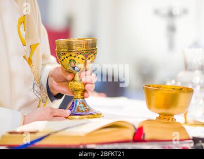 In der Kirche wird Wein zum Blut christi, und die Hostie wird zum Leib christi Stockfoto