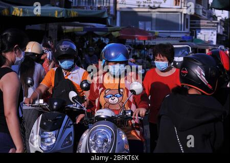 Kambodschaner tragen Schutzmaske / Abdeckungen, Motorrad-Verkehr außerhalb des russischen Marktes während der Coronavirus-Pandemie. Phnom Penh, Kambodscha. © Kraig Lieb Stockfoto