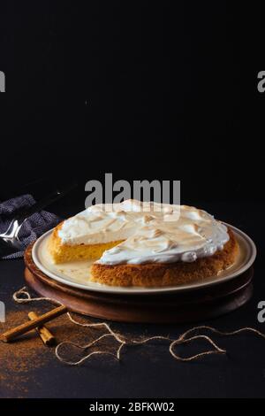 Hausgemachte Zubereitung einer drei-Milch-Tarte. Das Bild ist auf einem dunklen Hintergrund und rustikalen Bretter gemacht. Venezolanischer Kuchen Stockfoto