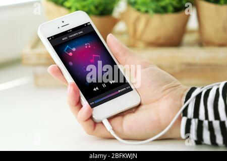 Musik Smartphone in weiblicher Hand, auf hellen Hintergrund Stockfoto