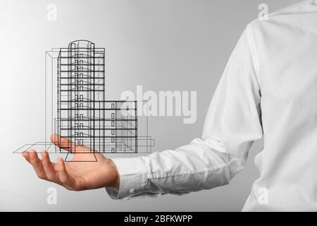 Immobilienangebot. Geschäftsmann hält ein künstliches Modell des Hauses Stockfoto