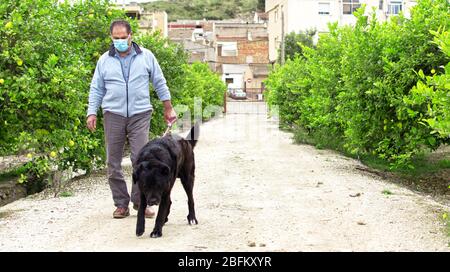 Ein Mann geht mit seinem Hund nach draußen, nachdem Spanien eine Sperre auferlegt hatte, um die Ausbreitung der Coronavirus-Krankheit in Murcia, Spanien, 19. April 2020, zu verlangsamen Stockfoto