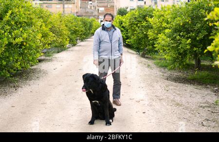 Ein Mann geht mit seinem Hund nach draußen, nachdem Spanien eine Sperre auferlegt hatte, um die Ausbreitung der Coronavirus-Krankheit in Murcia, Spanien, 19. April 2020, zu verlangsamen Stockfoto