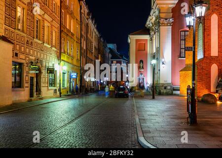 Warschau, Polen - 11. September 2019: Swietojanska Straße in der Altstadt bei Nacht, gesäumt von Stadthäusern und Kirchen, historisches Stadtzentrum Stockfoto