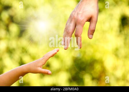 Hände von Vater und Sohn halten sich gegenseitig Stockfoto