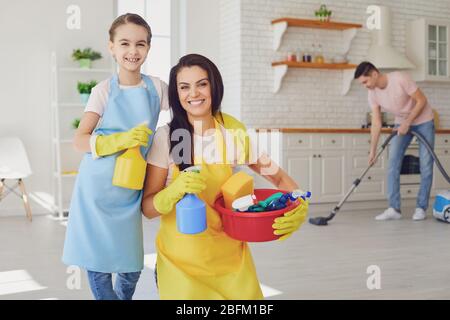 Die glückliche Familie reinigt das Zimmer im Haus. Stockfoto