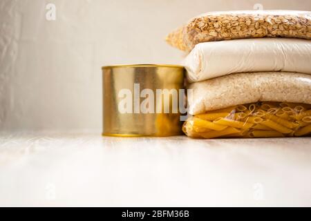 Spende Hilfe Nahrungsmittelversorgung Lieferung Getreide, Pasta, Konserven auf weißem natürlichen Holzhintergrund. Stockfoto