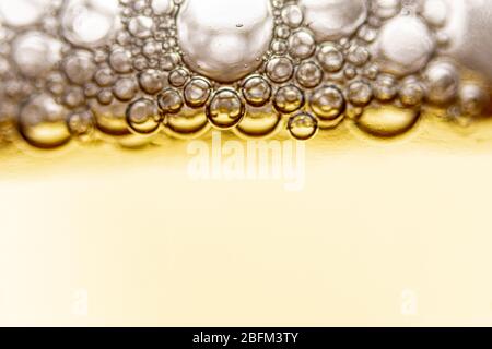 Textur von Schaum und Blasen in leichtem Bier. Abstrakte Kulisse für Design. Stockfoto