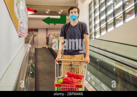 Alarmierte Mann trägt medizinische Maske gegen Coronavirus beim Lebensmitteleinkauf im Supermarkt oder Geschäft - Gesundheit, Sicherheit und Pandemie Konzept - junge Frau Stockfoto