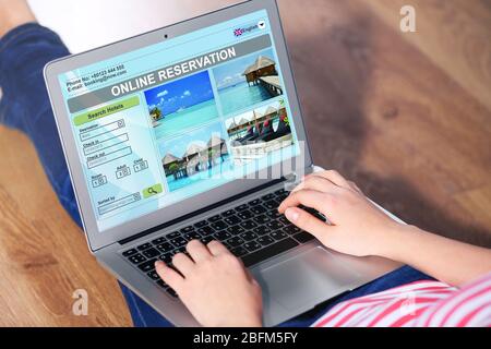 Frau, die online ein Hotel mit einem Laptop bucht Stockfoto