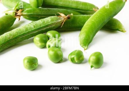 Die Kerne und die Schoten der grünen Erbsen in der Masse auf dem weißen Hintergrund Stockfoto