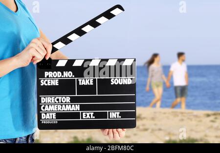 Bediener hält Klappertafel während der Produktion von Film im Freien Stockfoto