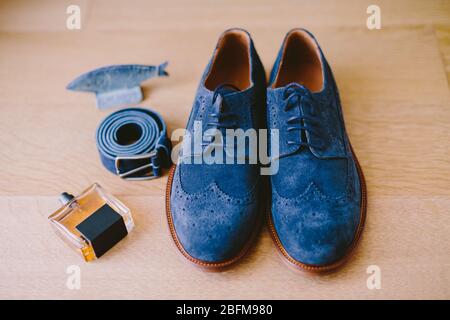 Herrenschuhe mit Gürtel und Parfüm. Die Accessoires für Männer lagen flach. Modische Schuhe und Gürtel. Stockfoto