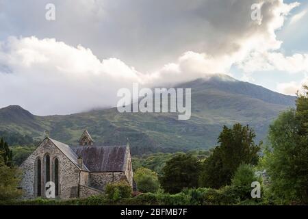 St. Mary's Church in Beddgelert mit Berglandschaft im Hintergrund, Snowdonia, Wales Stockfoto