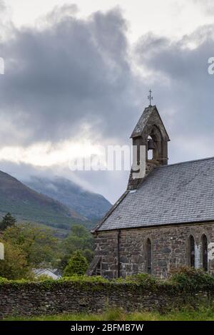 St. Mary's Church in Beddgelert mit Berglandschaft im Hintergrund, Snowdonia, Wales Stockfoto