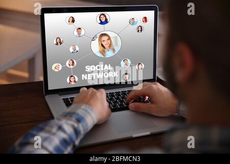 Mann, der mit einem Laptop arbeitet. Struktur sozialer Netzwerke auf dem Bildschirm Stockfoto