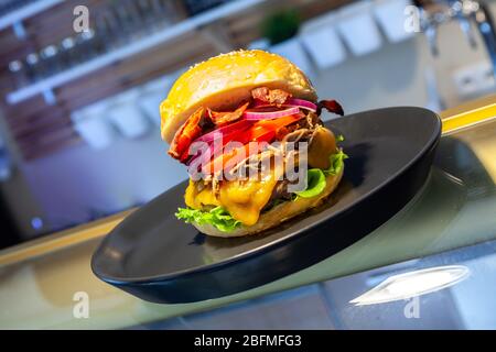 Nahaufnahme von hausgemachten leckeren Burgern auf dem Teller im Restaurant. Stockfoto