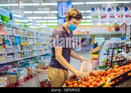 Man wählt Tomaten in einem Supermarkt ohne Plastikbeutel. Wiederverwendbare Tasche für den Kauf von Gemüse. Konzept ohne Verschwendung Stockfoto