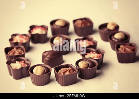 Set von Schokolade Bonbons auf hellem Holzhintergrund, Nahaufnahme Stockfoto