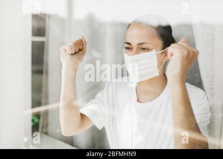 Der wütende Patient im Krankenhaus Coronavirus Quarantäne Selbstisolierung will nach draußen gehen. Pandemie-Covid-19-Kontrolle. Stockfoto