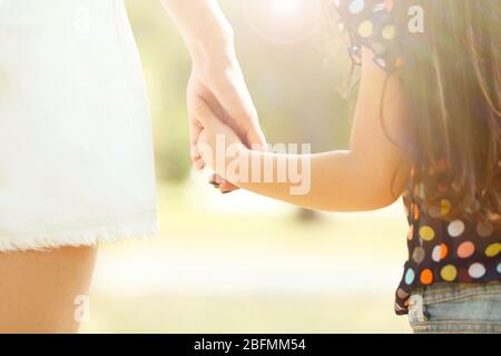 Die Mutter von Hand führen ihr Kind Tochter im Freien, vertrauen Familie Konzept Stockfoto