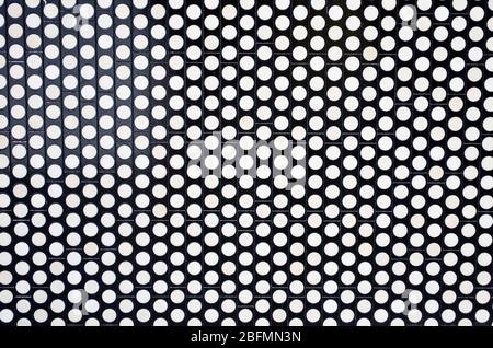 Weiße Kreise auf einem schwarzen metallischen Hintergrund in Form einer Fliese Stockfoto