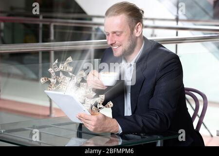 Finanzkonzept. Verdienen Sie Geld im Internet. Junge attraktive Geschäftsmann Mittagessen und arbeiten in einem Café Stockfoto