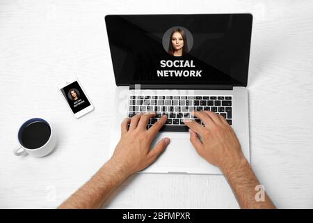 Mann, der mit einem Laptop arbeitet. Soziale Netzwerke auf dem Bildschirm Stockfoto