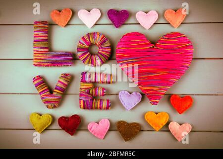 Valentinstag Konzept. Komposition aus bunten handgefertigten Herzen auf Holzhintergrund Stockfoto