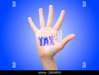 Steuerkonzept. Frauenhand mit Steuerzeichen, auf blauem Hintergrund Stockfoto