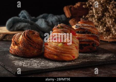 Kraffine mit Rosinen, kandierten Früchten und Mohn, mit Puderzucker bestreut. Stockfoto