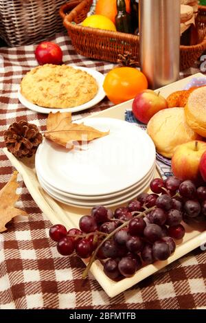 Zusammensetzung von Tellern, frischem Obst und Backen auf karierten Tischdecken Stockfoto