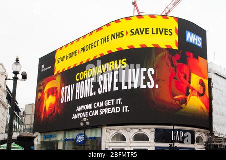 Bleib Zu Hause. Schützen Sie das NHS. Leben Retten. Eine Anzeige von der britischen Regierung wird auf dem Werbungsbildschirm im piccadilly Zirkus, zentralem Lon angezeigt Stockfoto