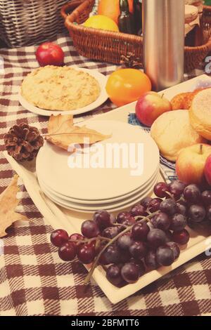 Zusammensetzung von Tellern, frischem Obst und Backen auf karierten Tischdecken Stockfoto