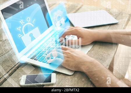 Mann arbeitet auf Laptop mit Symbolen Sicherheit auf virtuellen Display. Technologie-, Internet- und Netzwerkkonzept. Stockfoto