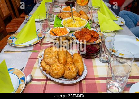 Ein Haufen gebratener, gefüllter polnischer Kroketten, die auf einem dekorierten Tisch liegen, sichtbare Pilze und Rüben. Stockfoto