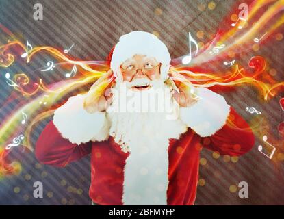 Weihnachtsmann in Kopfhörer mit Musik-Streaming von ihm Stockfoto