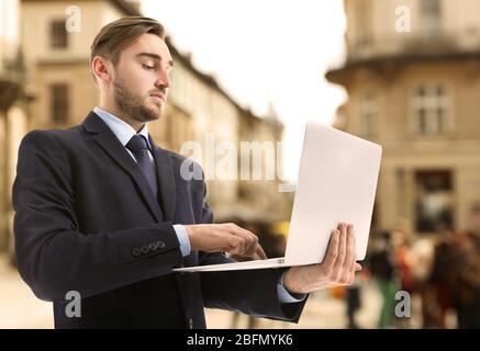 Junger Stadtmann mit Laptop Stockfoto