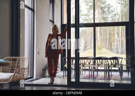 Zufrieden elegante Geschäftsfrau steht in ihrem Büro Stockfoto