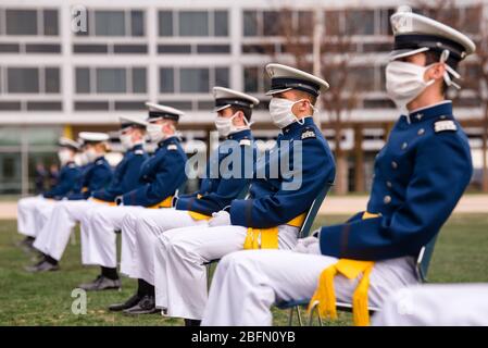 Colorado Springs, Vereinigte Staaten Von Amerika. April 2020. Die US-Luftwaffenkadetten mit Gesichtsmasken sitzen auf dem Terrazzo am Beginn der Abschlussfeier 2020 in der Air Force Academy am 18. April 2020 in Colorado Springs, Colorado. Kadetten mussten aufgrund der COVID-19, der Coronavirus-Pandemie, 8 Fuß bleiben. Quelle: Trang Le/US Air Force/Alamy Live News Stockfoto