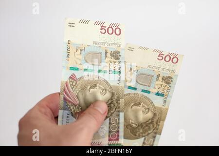 Nahaufnahme von zwei Banknoten im Nennwert von 500 PLN polnisches Geld, Zloty in den Händen auf weißem Hintergrund gehalten Stockfoto