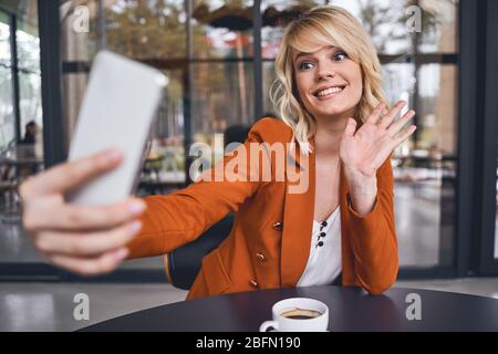 Frau mit Smartphone, die Spaß an der Arbeit hat Stockfoto