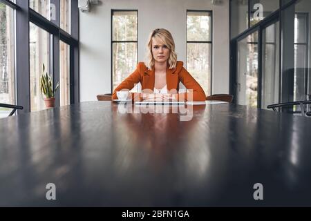 Seriöse blonde Dame sitzt in ihrem Büro Stockfoto