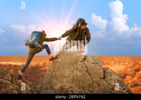 Helfen Hände mit Sonnenlicht zwischen zwei Kletterer Stockfoto