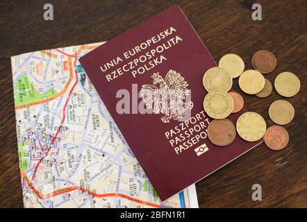 Tschenstochau, Polen - 18. April 2020: Europäische Union Republik Polen Reisepass, Münzen und Stadtplan auf Holzhintergrund Stockfoto